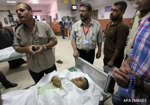 Palestinians mourn over the body of their relative, who medics said he was killed in an Israeli air strike, at a hospital in Khan Younis in the southers Gaza Strip July 22, 2014. A series of Israeli air strikes early kil...