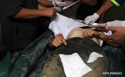 Palestinian medics prepare the body of Mohammed Abdul Ghafoor,who medics said was killed by Israeli soldiers in eastern border, at a hospital in Khan Younis in the southers Gaza Strip July 22, 2014. A series of Israeli a...