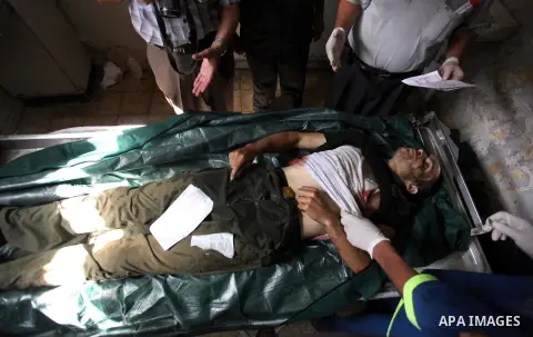 Palestinian medics prepare the body of Mohammed Abdul Ghafoor,who medics said was killed by Israeli soldiers in eastern border, at a hospital in Khan Younis in the southers Gaza Strip July 22, 2014. A series of Israeli a...