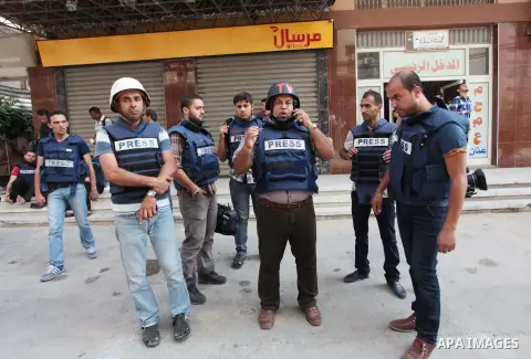 Palestinian journalists and reporters, who work in al-Jazeera Qatari television channel, stand outside their offices in Gaza City on July 22, 2014. Al Jazeera staffers evacuated their newsroom in Gaza City on Tuesday, sa...