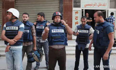 Palestinian journalists and reporters, who work in al-Jazeera Qatari television channel, stand outside their offices in Gaza City on July 22, 2014. Al Jazeera staffers evacuated their newsroom in Gaza City on Tuesday, sa...