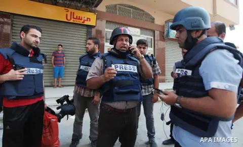 Palestinian journalists and reporters, who work in al-Jazeera Qatari television channel, stand outside their offices in Gaza City on July 22, 2014. Al Jazeera staffers evacuated their newsroom in Gaza City on Tuesday, sa...