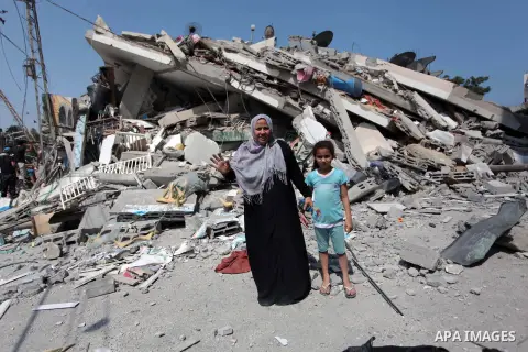 A Palestinian woman stands in front of the rubble of a residential building, which police said was destroyed in an Israeli air strike, in Gaza City July 22, 2014. Israel kept up its assaults in the Gaza Strip on Tuesday,...