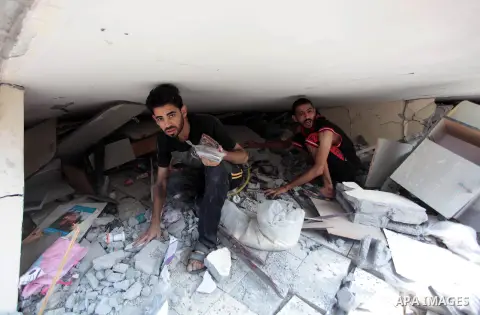 Palestinians search in the rubble of a residential building, which police said was destroyed in an Israeli air strike, in Gaza City July 22, 2014. Israel kept up its assaults in the Gaza Strip on Tuesday, killing three P...