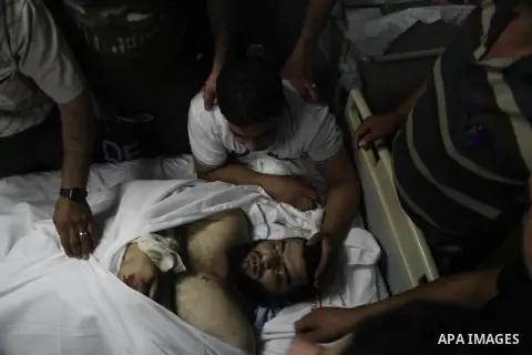 Relatives of killed Palestinian Mahmud al-Hamamra, 32, mourn over his body at a hospital in Hebron on July 22, 2014 after he was shot to death by israeli soldiers during clashes in the West Bank village of Husan, near Be...