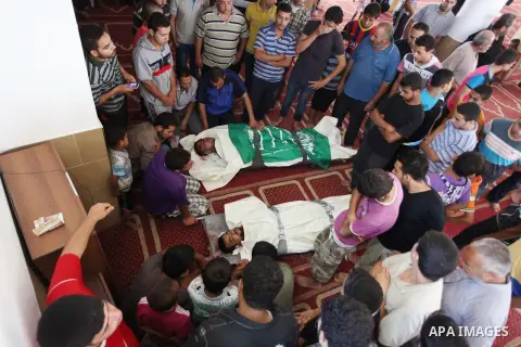 Relatives gather around the lifeless bodies of Palestinian cousins Adnan Habib, 22, foreground, and Mahmoud Habib, 27, killed in separate incidents earlier Wednesday, on the sixteenth day of the war in Gaza, during their...