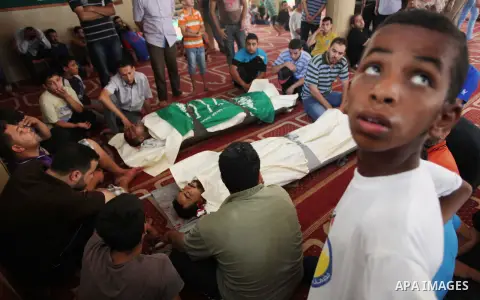 Relatives gather around the lifeless bodies of Palestinian cousins Adnan Habib, 22, foreground, and Mahmoud Habib, 27, killed in separate incidents earlier Wednesday, on the sixteenth day of the war in Gaza, during their...