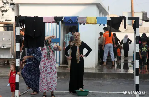 Displaced Palestinians from Beit Hanun in the northern Gaza Strip gather on July 23, 2014 at a UN school in the refugee camp of Jabalia where families fleeing heavy fighting in the besieged Palestinian territory have tak...