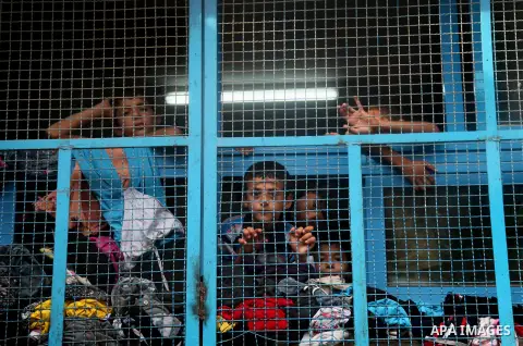 Displaced Palestinian children from Beit Hanun in the northern Gaza Strip stand behind the window of a classroom on July 23, 2014 at a UN school in the refugee camp of Jabalia where displaced families have taken refuge a...