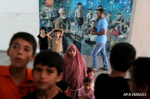 Displaced Palestinians from Beit Hanun in the northern Gaza Strip gather on July 23, 2014 at a UN school in the refugee camp of Jabalia where families fleeing heavy fighting in the besieged Palestinian territory have tak...