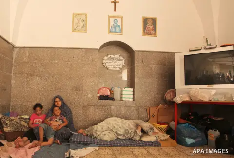 Displaced Palestinian women and children sit in a Greek Orthodox church where many Palestinians are taking shelter in Gaza City on July 23, 2014. For the first time in years, Gaza City's Greek Orthodox church is packed t...