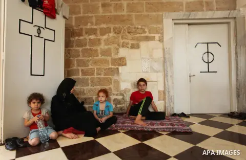 Displaced Palestinian women and children sit in a Greek Orthodox church where many Palestinians are taking shelter in Gaza City on July 23, 2014. For the first time in years, Gaza City's Greek Orthodox church is packed t...