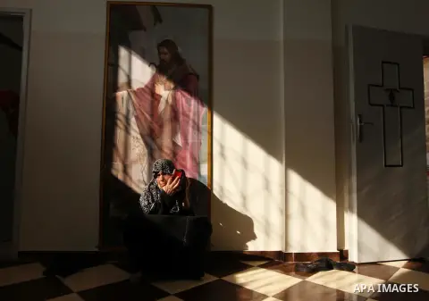 Displaced Palestinian women and children sit in a Greek Orthodox church where many Palestinians are taking shelter in Gaza City on July 23, 2014. For the first time in years, Gaza City's Greek Orthodox church is packed t...