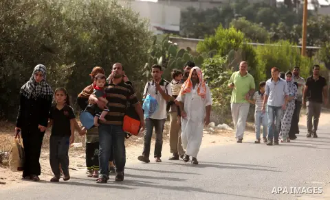 Palestinian families leave their neighborhood to a safer location as Israel's army continues shelling the area of Khan Yunis, in the southern Gaza Strip, on July 24, 2014. Seven Palestinians were killed in a series of st...