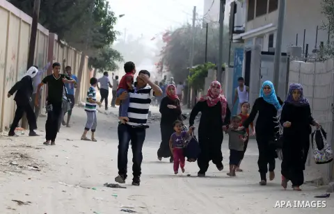 Palestinian families leave their neighborhood to a safer location as Israel's army continues shelling the area of Khan Yunis, in the southern Gaza Strip, on July 24, 2014. Seven Palestinians were killed in a series of st...