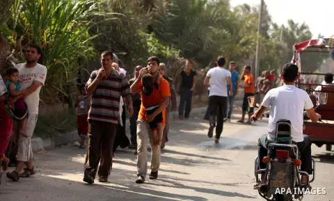 Palestinian families leave their neighborhood to a safer location as Israel's army continues shelling the area of Khan Yunis, in the southern Gaza Strip, on July 24, 2014. Seven Palestinians were killed in a series of st...