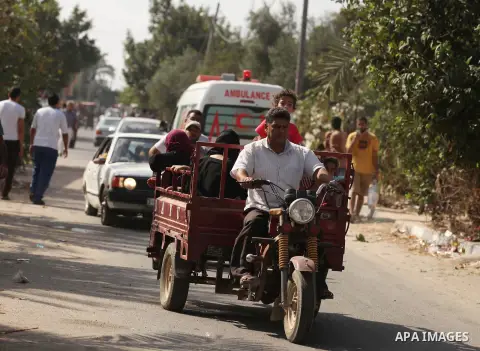 Palestinian families leave their neighborhood to a safer location as Israel's army continues shelling the area of Khan Yunis, in the southern Gaza Strip, on July 24, 2014. Seven Palestinians were killed in a series of st...