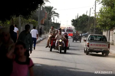 Palestinian families leave their neighborhood to a safer location as Israel's army continues shelling the area of Khan Yunis, in the southern Gaza Strip, on July 24, 2014. Seven Palestinians were killed in a series of st...