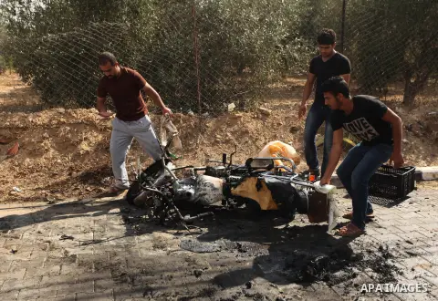 Palestinians inspect the remains of motorcycle that was hit by an Israeli air strike in Khan Yunis, in the southern Gaza Strip, on July 24, 2014. Seven Palestinians were killed in a series of strikes today in a flashpoin...