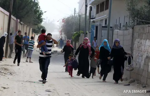 Palestinian families leave their neighborhood to a safer location as Israel's army continues shelling the area of Khan Yunis, in the southern Gaza Strip, on July 24, 2014. Seven Palestinians were killed in a series of st...