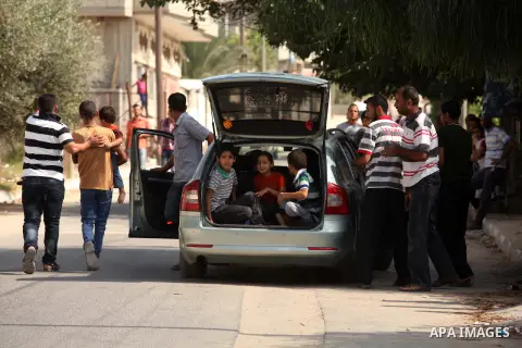 Palestinian families leave their neighborhood to a safer location as Israel's army continues shelling the area of Khan Yunis, in the southern Gaza Strip, on July 24, 2014. Seven Palestinians were killed in a series of st...