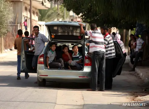 Palestinian families leave their neighborhood to a safer location as Israel's army continues shelling the area of Khan Yunis, in the southern Gaza Strip, on July 24, 2014. Seven Palestinians were killed in a series of st...