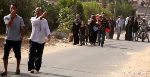 Palestinian families leave their neighborhood to a safer location as Israel's army continues shelling the area of Khan Yunis, in the southern Gaza Strip, on July 24, 2014. Seven Palestinians were killed in a series of st...