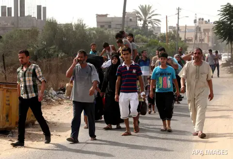 Palestinian families leave their neighborhood to a safer location as Israel's army continues shelling the area of Khan Yunis, in the southern Gaza Strip, on July 24, 2014. Seven Palestinians were killed in a series of st...