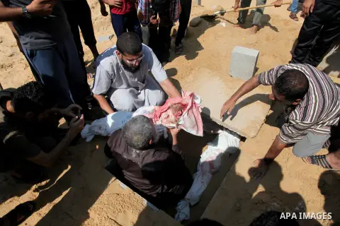 Palestinians bury the bodies of two Palestinian boys Abdulrahamn Abed al-Nabi, 1, and Hadi Abed al-Nabi, 3, who medics said were killed in an Israeli air strike, during their funeral at a cemetery in the northern Gaza St...