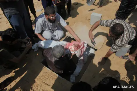 Palestinians bury the bodies of two Palestinian boys Abdulrahamn Abed al-Nabi, 1, and Hadi Abed al-Nabi, 3, who medics said were killed in an Israeli air strike, during their funeral at a cemetery in the northern Gaza St...