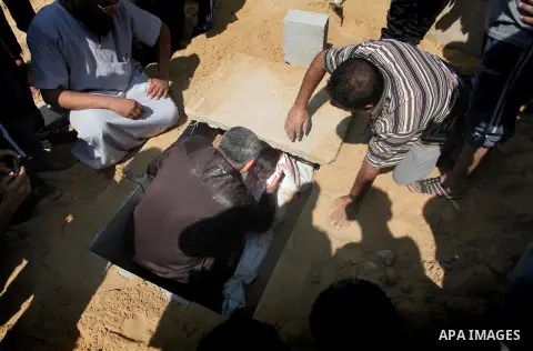 Palestinians bury the bodies of two Palestinian boys Abdulrahamn Abed al-Nabi, 1, and Hadi Abed al-Nabi, 3, who medics said were killed in an Israeli air strike, during their funeral at a cemetery in the northern Gaza St...