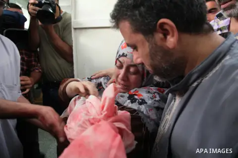 Palestinians bury the bodies of two Palestinian boys Abdulrahamn Abed al-Nabi, 1, and Hadi Abed al-Nabi, 3, who medics said were killed in an Israeli air strike, during their funeral at a cemetery in the northern Gaza St...