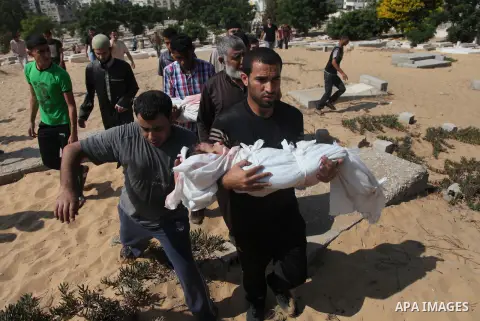 Palestinians bury the bodies of two Palestinian boys Abdulrahamn Abed al-Nabi, 1, and Hadi Abed al-Nabi, 3, who medics said were killed in an Israeli air strike, during their funeral at a cemetery in the northern Gaza St...