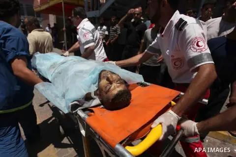 Medics wheel a stretcher carrying the body of Man, who medics said was killed by an Israeli air strike, at Nasser hospital in Khan Younis in the southern Gaza Strip July 24, 2014. Photo by Ashraf Amra