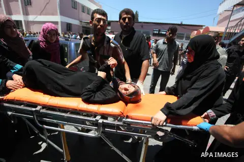 Palestinians wheel a stretcher transporting a woman, who medics said was wounded by an Israeli air strike, at a hospital in Khan Younis in the southern Gaza Strip July 24, 2014. Israel won a partial reprieve from the eco...