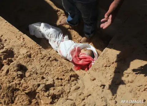 A Palestinian man buries the body of one-year-old baby Noha Mesleh, who died of wounds sustained after a UN school in Beit Hanun was hit by an Israeli tank shell, during her funeral in Beit Lahia, northern Gaza Strip, on...
