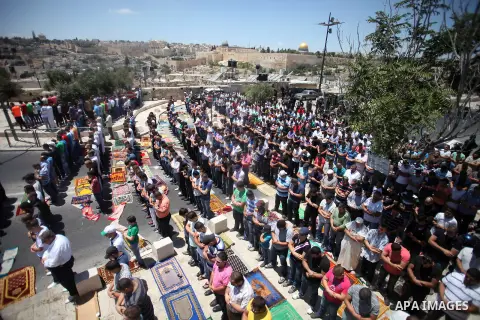 Israeli armed policemen stand guard behind Palestinian Muslims performing the traditional Friday prayers near the Old City in East Jerusalem on July 25, 2014. Israeli security forces are on heightened alert after a Pales...