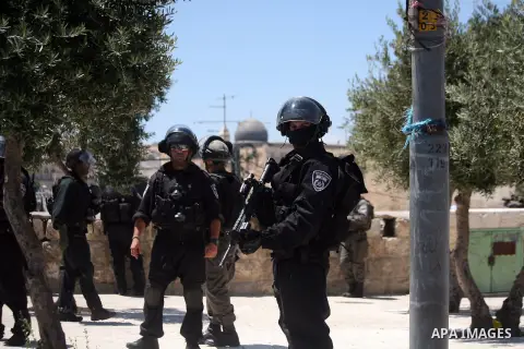 Israeli armed policemen stand guard behind Palestinian Muslims (not seen) performing the traditional Friday prayers near the Old City in East Jerusalem on July 25, 2014. Israeli security forces are on heightened alert af...