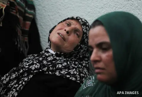 Palestinian relatives of a man, killed in an Israeli strike on a compound housing a U.N. school in Beit Hanoun, mourn at the Kamal Adwan hospital, in Beit Lahiya in the northern Gaza Strip, Thursday, July 24, 2014. Israe...