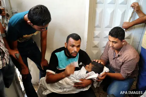 A Palestinian man cries over the body of his son, Wleed Al-Harazeen, who was Killed by Israeli army sniper in Shijaiya in Gaza City, on 25 July 2014. An Israeli defense official says the Israeli Security Cabinet is meeti...