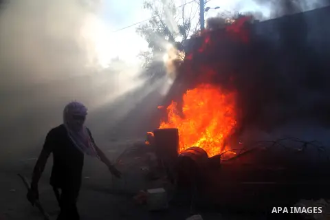 Palestinian protesters block Route 60, the main Jewish settler road during the funeral of three Palestinians, who medics said were killed during clashes with Israeli troops, in Beit Ommar town north of the West Bank city...