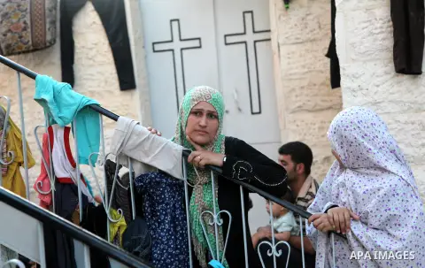 Displaced Palestinian gather of Iftar meal at a Greek Orthodox church where many Palestinians are taking shelter in Gaza City on July 25, 2014. US Secretary of State John Kerry entered new meetings with UN chief Ban Ki-m...