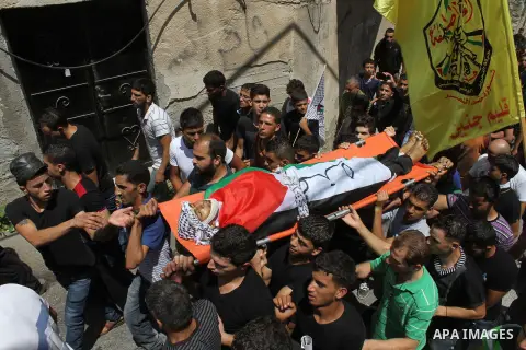 Palestinians carry the body of Bassem Abo Al-Rob, 19, during his funeral in the West Bank village of Kabatyeh near Jenin city on Saturday, July 26, 2014. Abo Al-Rob was shot during clashes that started late Friday with I...