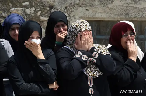 Palestinian women mourn over the body of Bassem Abo Al-Rob, 19, during his funeral in the West Bank village of Kabatyeh near Jenin city on Saturday, July 26, 2014. Abo Al-Rob was shot during clashes that started late Fri...