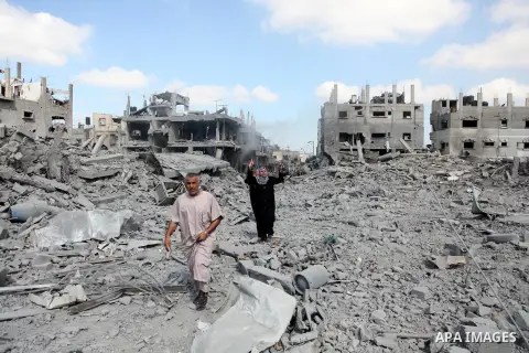 Palestinians walk on the rubble as they enter the northern district of Beit Hanun to check their homes in the Gaza Strip during an humanitarian truce on July 26, 2014. Palestinians retrieved dozens of bodies from the rub...