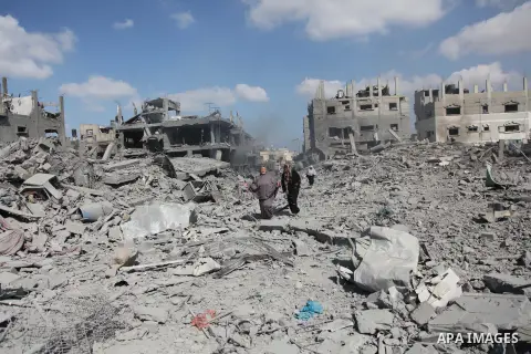 Palestinians walk on the rubble as they enter the northern district of Beit Hanun to check their homes in the Gaza Strip during an humanitarian truce on July 26, 2014. Palestinians retrieved dozens of bodies from the rub...