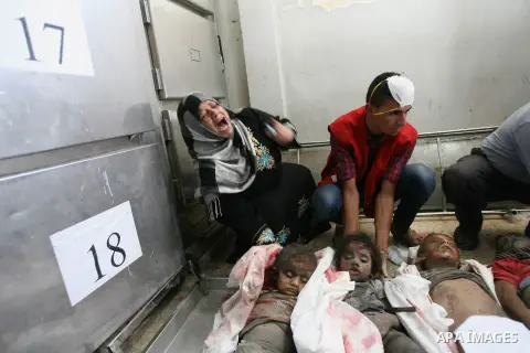 Palestinian gather around the bodies of Palestinian children from the al-Najar family, who medics said were killed by an Israeli air strike on their house, at a hospital morgue in Khan Younis in the southern Gaza Strip J...