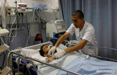 A Palestinian man, who medics said was wounded in an Israeli air strike in Gaza Strip, receives treatment at Saint Joseph Hospital, in Sheikh Jarrah in Jerusalem on July 26, 2014. Dozens of Palestinian bodies were recove...