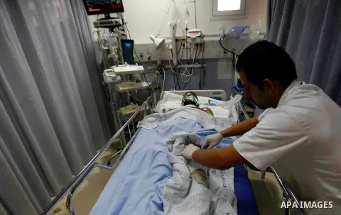 A Palestinian man, who medics said was wounded in an Israeli air strike in Gaza Strip, receives treatment at Saint Joseph Hospital, in Sheikh Jarrah in Jerusalem on July 26, 2014. Dozens of Palestinian bodies were recove...