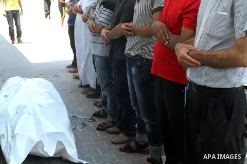 Mourners pray over the body of a Palestinian man, who medics said was killed in an Israeli shelling, at a street in Gaza City on July 26, 2014. Israeli forces have succeeded in destroying at least 1,900 houses and 22,800...